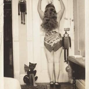 Untitled (Woman posed from behind against door with hanging skeleton)