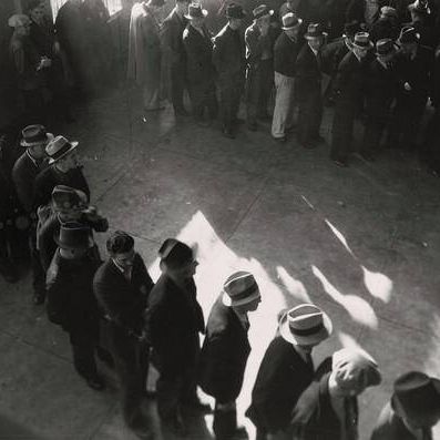 Line of men inside a division office of the State Employment Service office at San Francisco, California, waiting to register for unemployment benefits