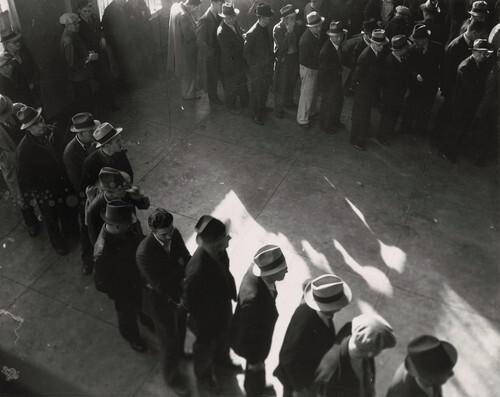 Line of men inside a division office of the State Employment Service office at San Francisco, California, waiting to register for unemployment benefits