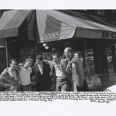 Bob Donlon (Rob Donnelly, Kerouac’s Desolation Angels), Neal Cassady, myself in black corduroy jacket, Bay Area poets’ “Court Painter” Robert La Vigne & poet Lawrence Ferlinghetti in front of his City Lights Books shop, Broadway & Columbus Avenue North Beach. Donlon worked seasonally as Las Vegas waiter & oft drank with Jack K., Neal looks good in tee shirt, Howl first printing hadn’t arrived from England yet (500 copies), we were just hanging around, Peter Orlovsky stepped back off curb & snapped shot, San Francisco spring 1956.