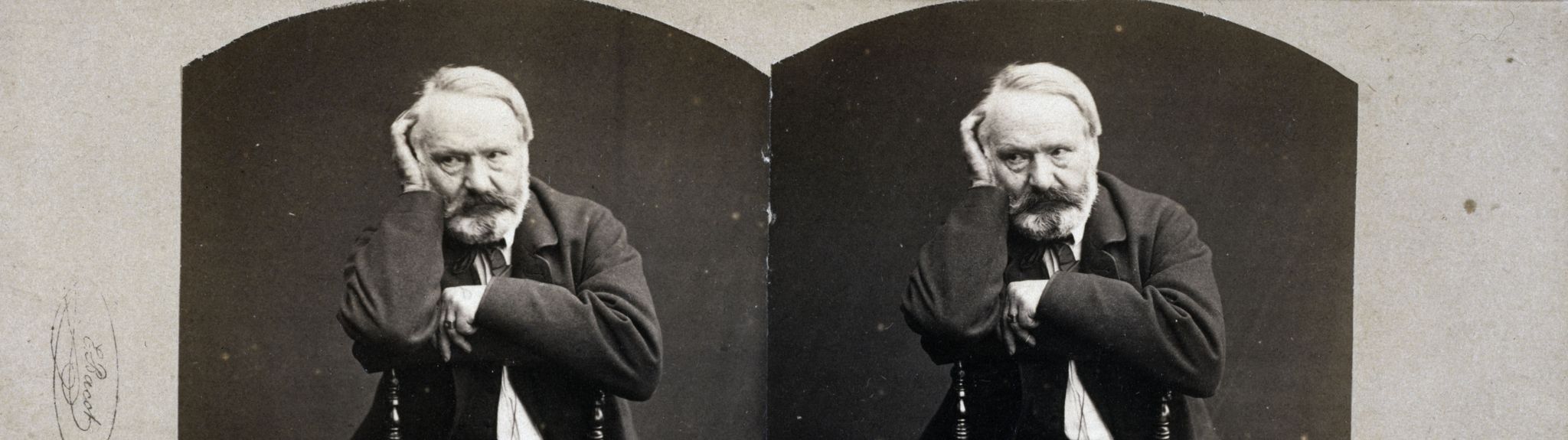 Victor Hugo, assis à califourchon sur une chaise