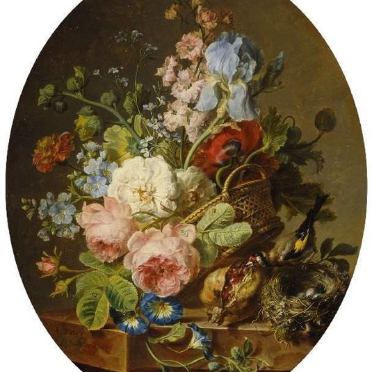 Open wicker basket of mixed flowers, including iris, roses, poppies, hollyhock, marygold, larkspur and convolulus on a marble ledge with an open pomegrante and a goldfinch with its nest