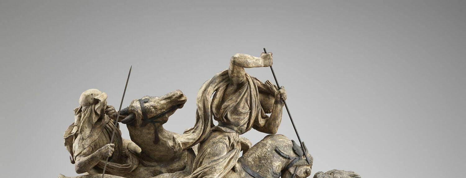A lion and a lioness fighting over a wounded buffalo with Bedouin horsemen