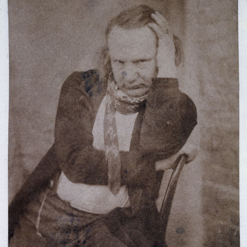 Victor Hugo de face assis et main gauche tenant la tête