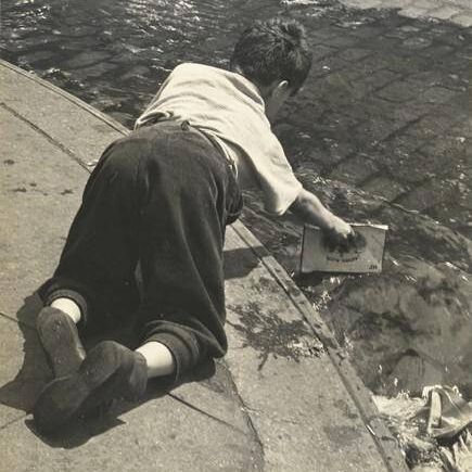 Boy Playing with Water in Street