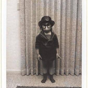 Untitled (Girl with fake glasses and nose in front of curtain)
